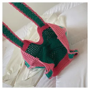 Detail of pink and green hand-knit crochet tote bag showing hollow mesh stitch texture