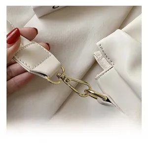 Detail view of premium pale gold metal hook and fine leather texture of the cloud bag