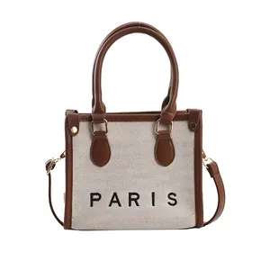 Minimalist canvas tote bag with brown faux leather trim and Paris text print