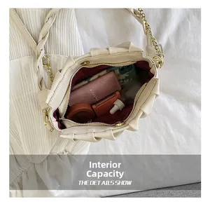 Internal capacity of off-white ruched cloud bag with woven handle and gold chain
