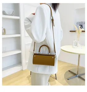Brown structured rectangular crossbody bag with top handle and silver metal hardware studs