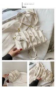 Detailed view of white pleated cloud bag with soft PU texture and golden metal chain