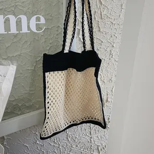 Vintage crochet tote bag with cream mesh body and black knit handles for summer style