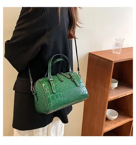 Close-up of shiny green faux leather Boston bag featuring detailed crocodile texture