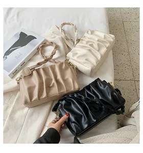 Detail of ruched shoulder bags in white, khaki, and black with braided strap design