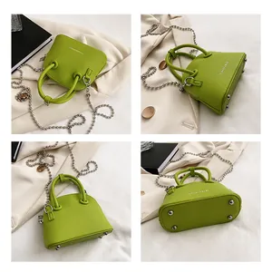 Detail view of grass green leather handbag with silver ball chain and metal bottom studs