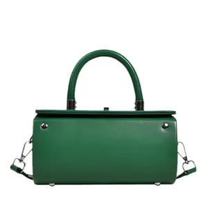 Chic emerald green cylinder handbag in smooth leather with silver hardware and shoulder strap