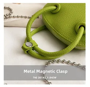Close-up of hardware magnetic clasp and lychee pattern leather on fruit green handbag
