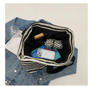 Internal structure of striped canvas tote bag showing zipper pocket and spacious interior
