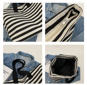 Detail view of striped canvas tote with zipper closure and internal pocket layout
