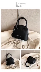Detail view of black pebble leather handbag featuring silver chain and round handle