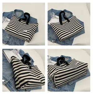 Detail view of large canvas tote bag with black and white stripes and sturdy handles
