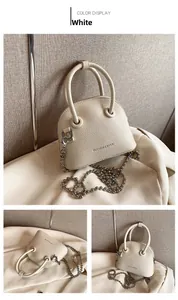 Detail view of white lychee textured mini bag with round handles and silver ball chain