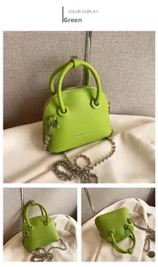 Detail view of green litchi texture crossbody bag with silver bead chain and handles