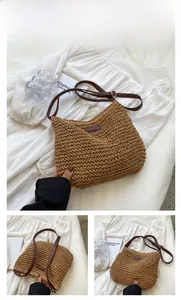 Detail view of woven straw tote bag with khaki texture and adjustable leather strap