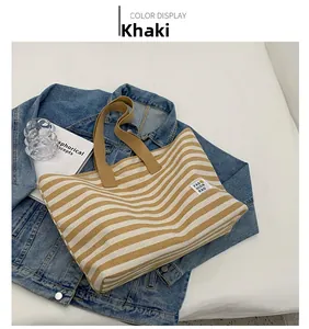 Detail of khaki and white striped canvas tote bag with a woven texture and fashion label
