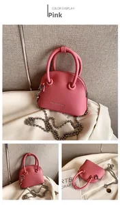 Detail view of pink lychee leather crossbody bag with chain strap and silver accents