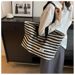 Detail of large canvas tote bag with black and white stripes and sturdy woven handles