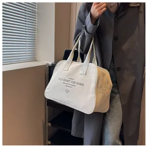 Detail shot of white canvas tote bag with vintage typography and reinforced wide handles