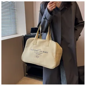 Detailed view of large off-white canvas tote bag with black print and zipper closure