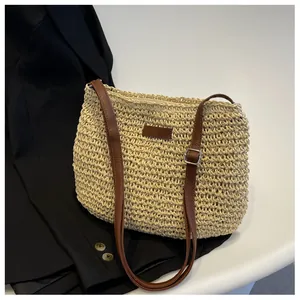 Close-up of handmade straw woven bag texture with brown leather strap and zip closure