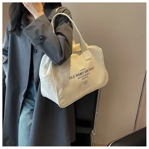 Close-up of off-white canvas tote bag with black vintage logo and durable top handles