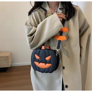 Detail of creative pumpkin shoulder bag with bat charms worn over a beige coat
