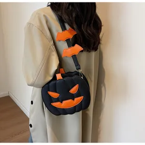 Close-up of black Halloween pumpkin crossbody bag with orange bat charms and silver hardware