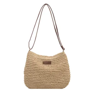 Summer casual straw shoulder bag with woven texture and slim brown strap on white background