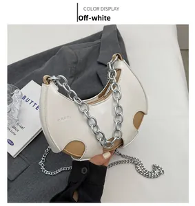 Vista dettagliata della borsa a mezzaluna beige con catena d'argento spessa e logo CGER