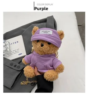 Detail of cute brown teddy bear plush bag wearing a purple hoodie with gold chain strap