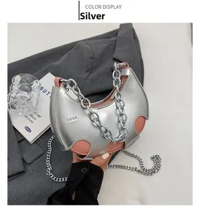 Dettaglio ravvicinato di una borsa a mezzaluna argento con catena e design traforato