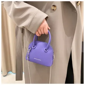 Detail of lilac cross-body bag featuring lychee texture and silver ball chain strap