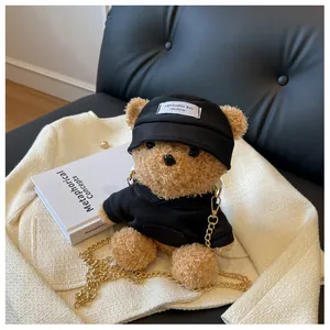 Detail of cute plush bear bag wearing a black hoodie and cap with golden chain strap