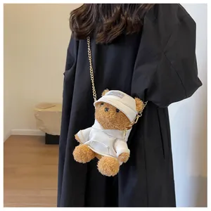 Detail of cute brown plush bear crossbody bag with mini white hoodie and gold chain strap