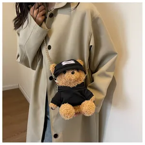 Detailed view of bear plush bag with gold chain strap and stylish black hoodie accessory
