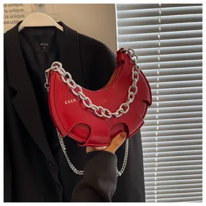Dettaglio borsa a mezzaluna rossa in pelle PU lucida con catena d'argento spessa