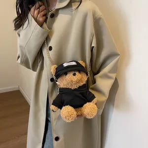 Cute brown plush bear crossbody bag with black hoodie, golden chain strap on a model