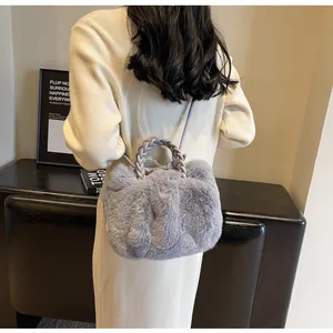 Detail of grey faux fur tote bag with braided handles on a model in knit dress