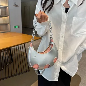 Borsa a mezzaluna argentata con catena, fodera rosa e design traforato chic da donna