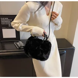 Detail view of a black fluffy faux fur tote bag with braided handles on a model