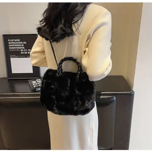 Détail du sac cabas en fausse fourrure noire avec texture douce et poignée tressée