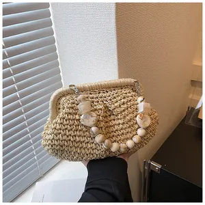 Detail of hand-woven straw handbag featuring elegant marble resin bead handle and texture