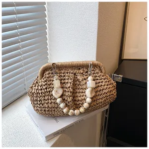Detail of hand-woven straw bag with marble bead handle and soft cloud pleat texture