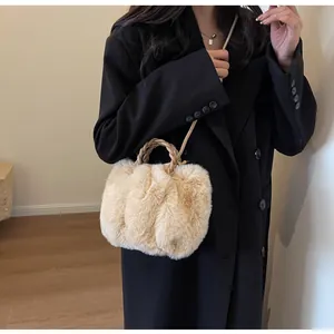 Close-up of plush faux fur tote with khaki woven handles and adjustable shoulder strap