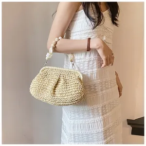 Detail of light beige woven straw bag with marble bead handle on white dress model