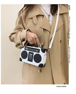 Dettaglio di una borsa a tracolla creativa a forma di radio retrò su una modella