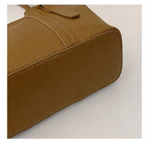 Close-up of precise stitching and lychee grain texture on a brown leather handbag