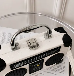 Detail of creative radio-shaped handbag showing silver metal handle and buckle closure