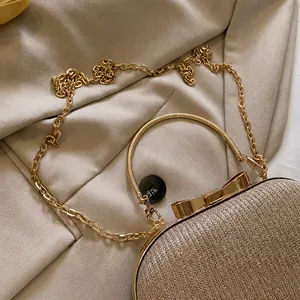 Detail of the high-quality gold metal chain strap on a glittery evening clutch bag